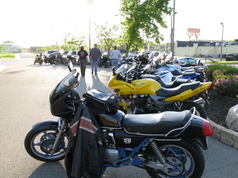 1985 Ford LTD Crown Victoria - Photograph of motorcycles parked in a lot, not a technical document.