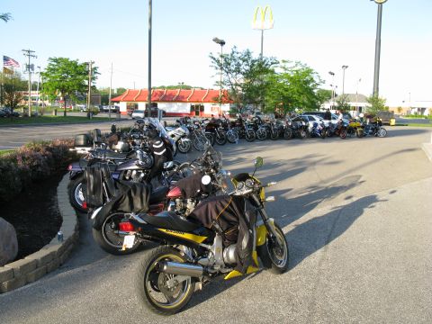 1985 Ford LTD Crown Victoria - A group of motorcycles are parked in a lot outside a McDonald's restaurant.