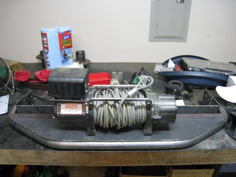 1996 Ford Bronco - A Chicago Electric electric winch with steel cable spooled on the drum sits mounted to a fabricated tube-and-plate front bumper on a workbe…