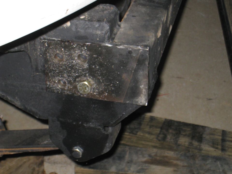 close-up of vehicle frame with bolted bracket and part of suspension