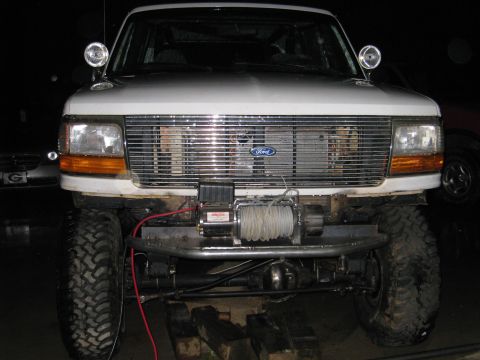1996 Ford Bronco - Front view of a white Ford Bronco with a winch mounted on an aftermarket bumper.