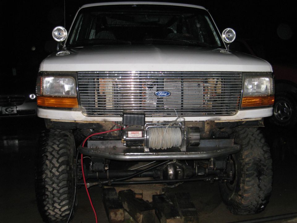 White Ford Bronco front end with chrome grille, winch, and aftermarket bumper