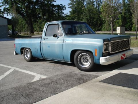 1979 Chevrolet C/K Pickup - This pickup truck has a lowered stance and custom wheels, suggesting modifications.