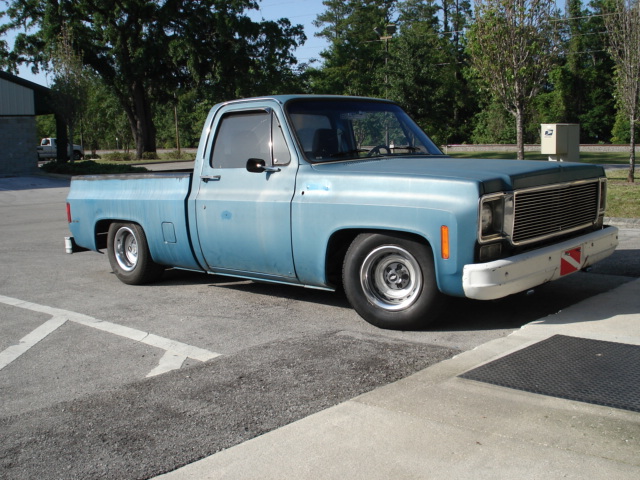 Light blue pickup truck with lowered suspension and aftermarket wheels