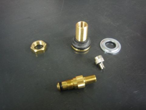 1987 Suzuki Samurai - Various brass and metal valve stem components are laid out on a dark surface.
