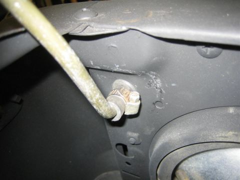 1987 Suzuki Samurai - Detail of a hose clamp securing a hose to a vehicle's body panel.