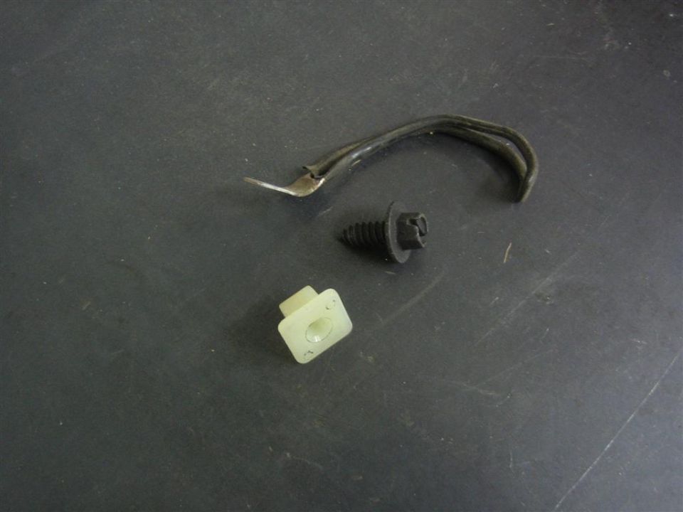 Hood prop rod with black push fastener and white nylon retaining clip on a bench