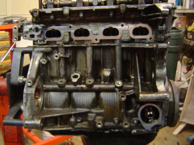 Close-up of a dirty engine block, likely from a 1997 Saturn SC.