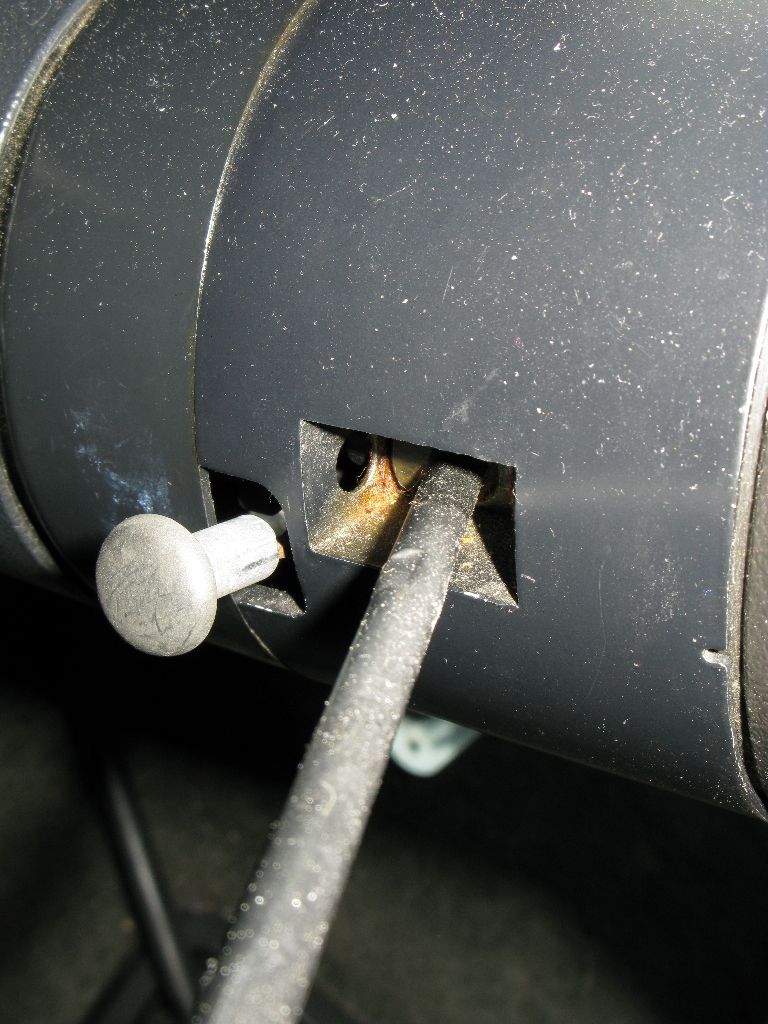 Close-up of a gray lever and black cable entering a dark gray housing on a vehicle.