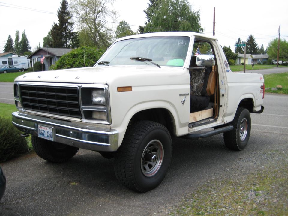 White 1980 Ford Bronco parked in driveway, driver door open