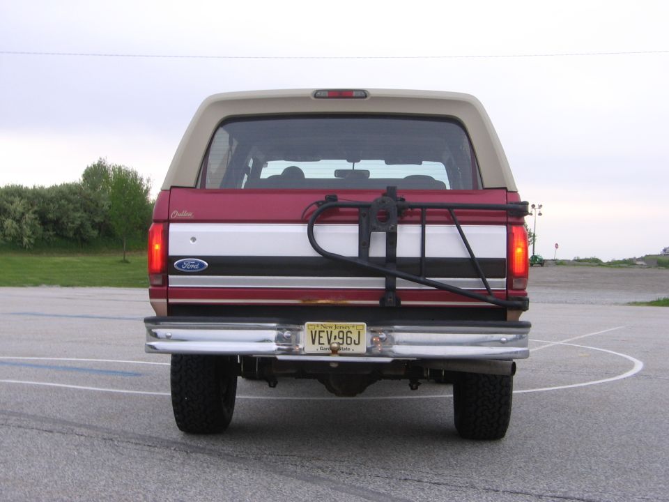Rear view of a red SUV with a license plate and text on the tailgate