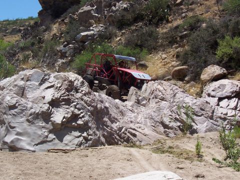 1981 Ford F-150 - A custom-built off-road buggy tackles a challenging rocky trail in a desert landscape.