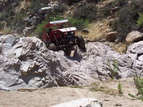 1981 Ford F-150 - This off-road buggy is captured mid-climb on a challenging rocky trail, its capabilities.