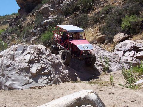 1981 Ford F-150 - Custom off-road buggy tackling a steep, rocky incline in a desert canyon.