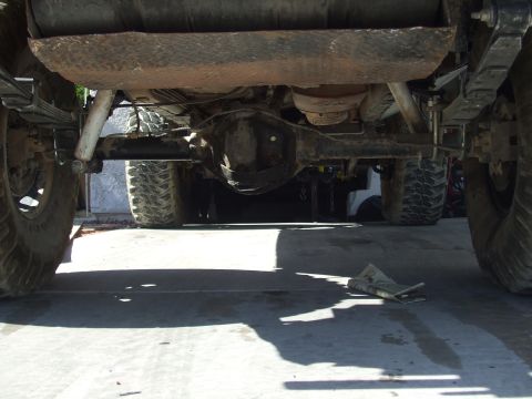1978 Jeep Cherokee - The underside of a vehicle shows its rear axle assembly, suspension components, and a portion of the fuel tank.