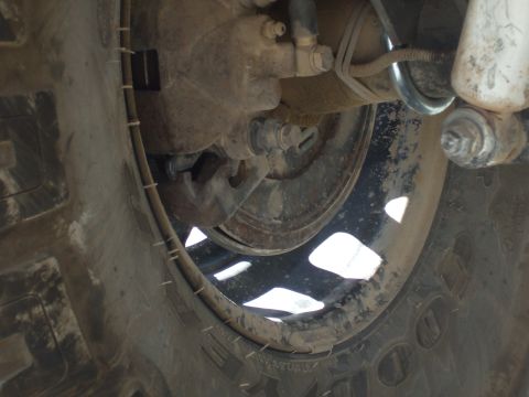 1978 Jeep Cherokee - A close-up view of a vehicle's wheel and axle assembly, revealing the tire, rim, and brake components.
