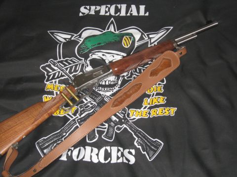 1990 Ford Bronco - A rifle with a leather sling and ammunition is displayed against a black t-shirt military-themed graphics and text.