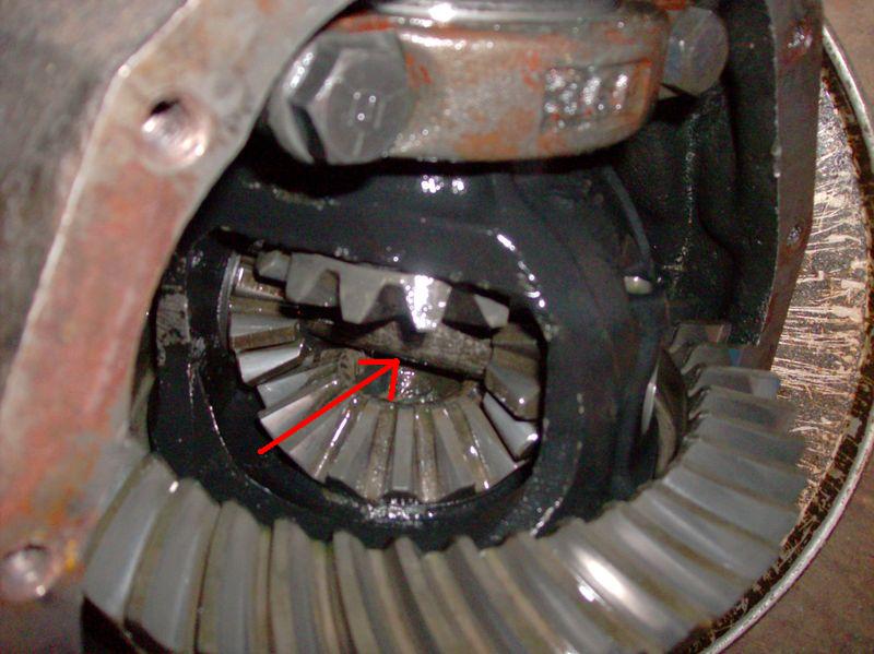 Close-up of differential gears with a red arrow pointing to a specific gear tooth