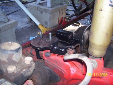 1978 Ford Bronco - Close-up view of a vehicle's suspension component, possibly a coil mount, with a yellow shock absorber visible.