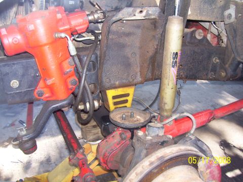1978 Ford Bronco - Close-up view of vehicle's steering and suspension system components, with visible hydraulic lines and hardware.