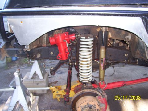1978 Ford Bronco - Vehicle suspension and steering parts are visible, supported by jacks.
