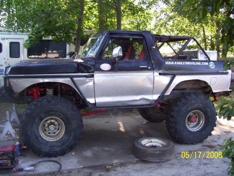 1978 Ford Bronco - Modified 1978 Ford Bronco with custom silver body panels and large off-road tires sits outdoors.