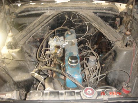 1965 Ford Ranchero - The engine compartment of a vehicle, showing the engine block, carburetor, and associated wiring.