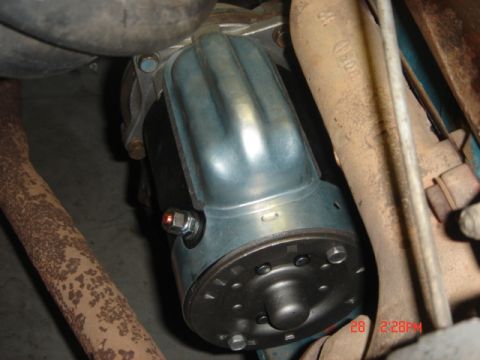 1965 Ford Ranchero - A starter motor is shown installed in a vehicle, surrounded by exhaust components.