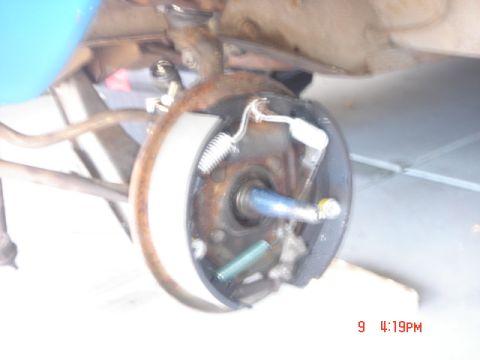1965 Ford Ranchero - Close-up of a vehicle's drum brake assembly, revealing internal components like springs and brake shoes.