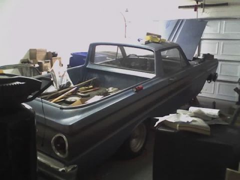 1965 Ford Ranchero - A blue 1965 Ford Ranchero is parked in a garage with its hood and trunk open, revealing tools in the bed.