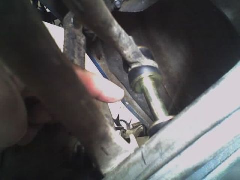 1965 Ford Ranchero - A hand is shown near a metallic suspension component, possibly during maintenance or inspection.