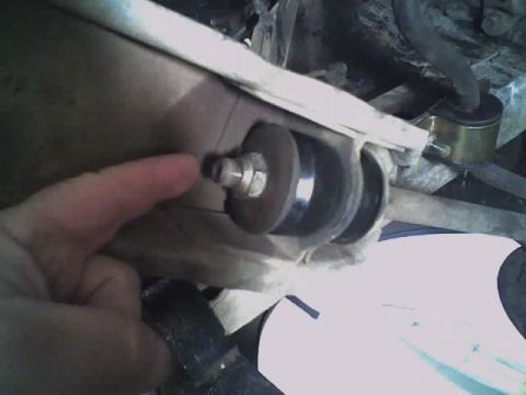 1965 Ford Ranchero - A finger points to a bolt on a vehicle's suspension system, highlighting a specific part.