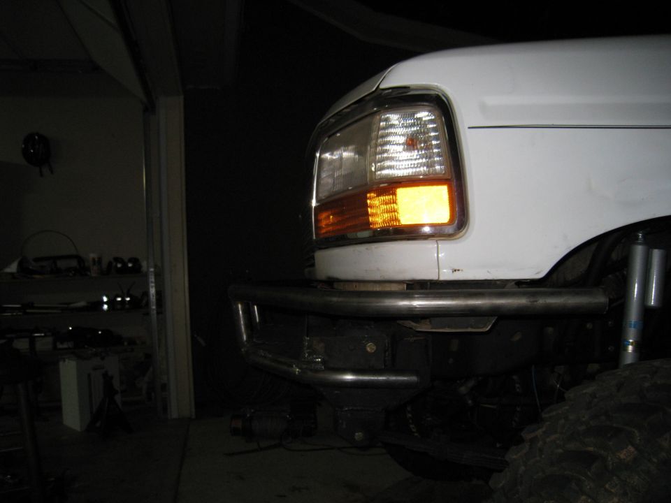 White Ford truck front end with aftermarket bumper and amber turn signal