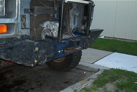 1986 Ford Bronco - Winch assembly mounted behind the front bumper of a vehicle.