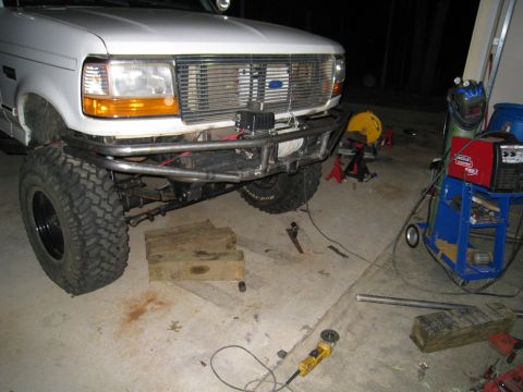 1996 Ford Bronco - This Ford truck features a custom bumper and winch, with welding equipment visible in the garage setting.