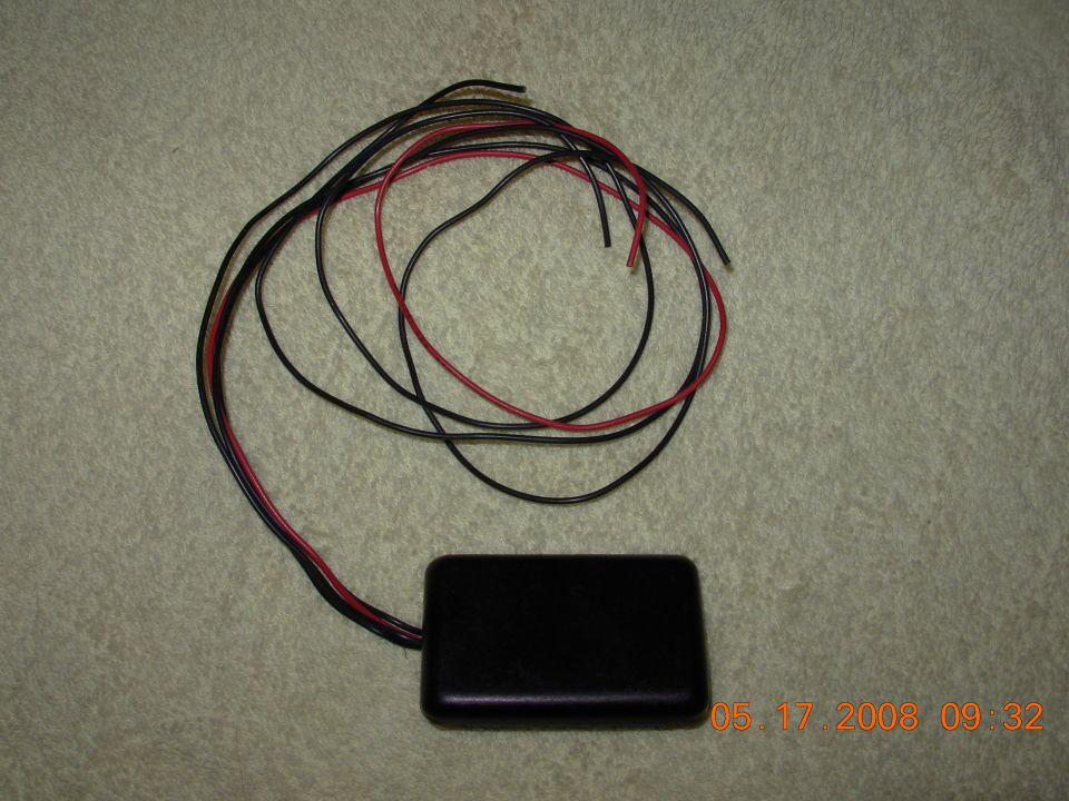 Black rectangular electronic module with a bundle of red and black wires