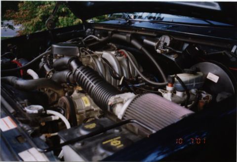 1994 Ford Bronco - The engine bay of a vehicle is shown with various components and a date stamp.