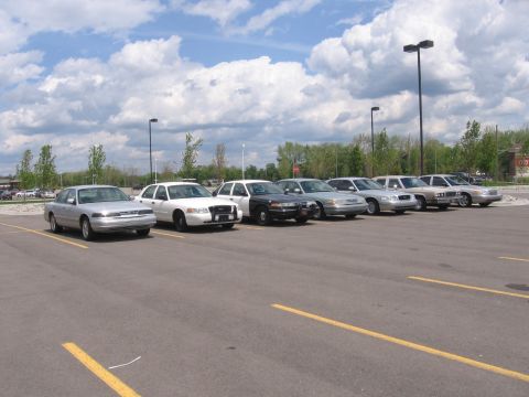1988 Mercury Grand Marquis - A silver sedan is parked in a lot with several other vehicles under a cloudy sky.