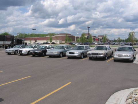 1988 Mercury Grand Marquis - A row of sedans, including a 1992 Mercury Grand Marquis, are parked in a lot under a cloudy sky.