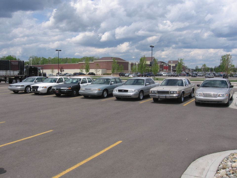 Several sedans parked in a lot, including a 1992 Mercury Grand Marquis
