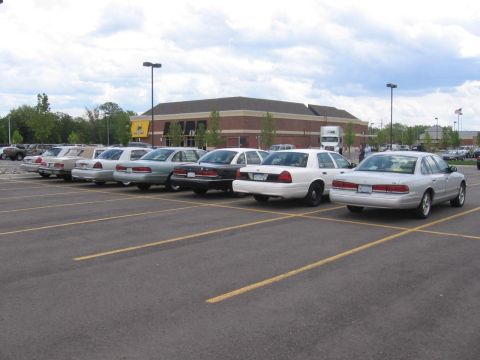 1988 Mercury Grand Marquis - Multiple Mercury Grand Marquis sedans are parked in a lot under a cloudy sky.