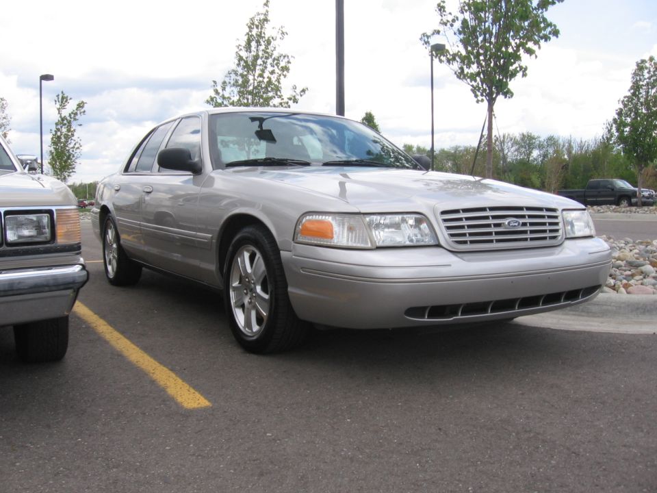 Silver sedan parked in a lot, front quarter view. The grille has horizontal bars and a Ford emblem