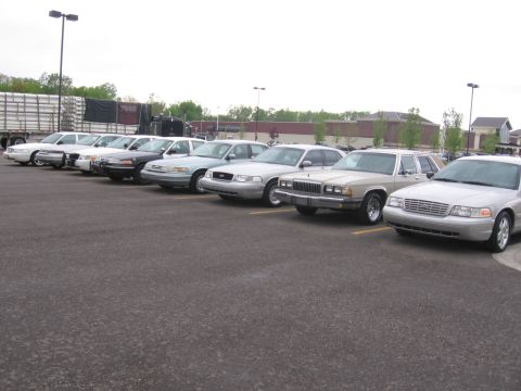 1988 Mercury Grand Marquis - Several sedans, including a 1988 Mercury Grand Marquis, are parked in a lot.