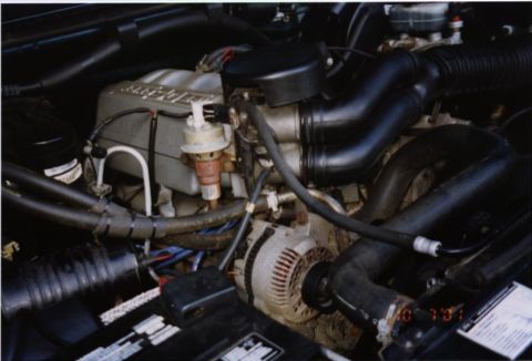 1994 Ford Bronco - Close-up of an engine bay, showing various components and hoses. Watermark present.