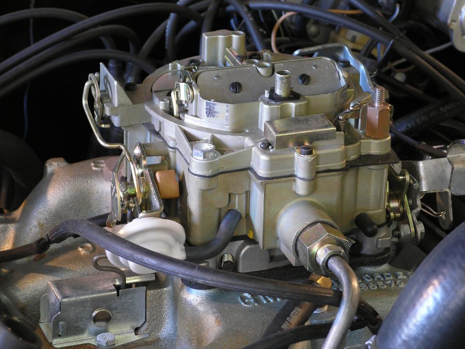 Holley carburetor with fuel lines and wiring, mounted on an engine