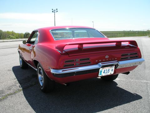1969 Pontiac Firebird - Rear view of a red 1969 Pontiac Firebird, showing its distinctive taillights and spoiler.