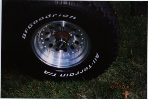 1994 Ford Bronco - Close-up of a BFGoodrich All-Terrain T/A tire and a multi-spoke alloy wheel resting on grass.