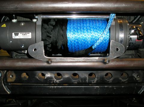 1986 Toyota Hilux - A close-up view of a WARN Series Wound Power winch mounted on a vehicle, featuring a bright blue synthetic rope and a black synthetic rope…