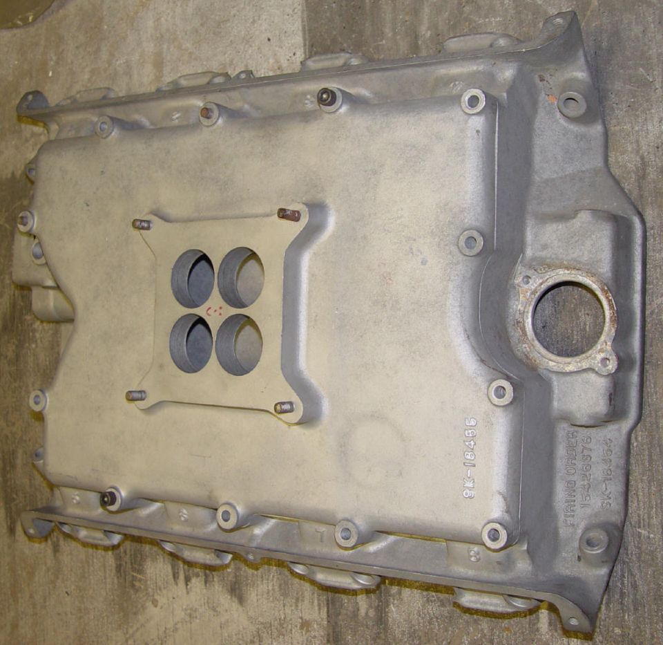 Bare aluminum four-barrel intake manifold with cast firing-order 15426378 on a concrete floor