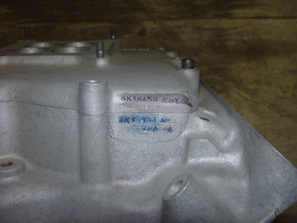 Close-up of silver automotive part with stamped text SK1845B ASSY and SK18453 ABSY 9A